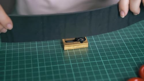 Person färbt Lederband mit reinem Kupfer schwarz ein