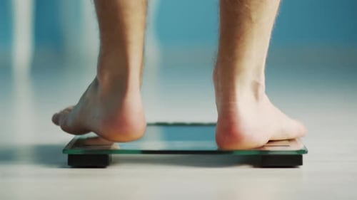 Person Weighing Themselves On Bathroom Scale, Close Up