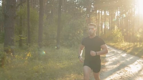 Man Jogging in Forest at Sunrise