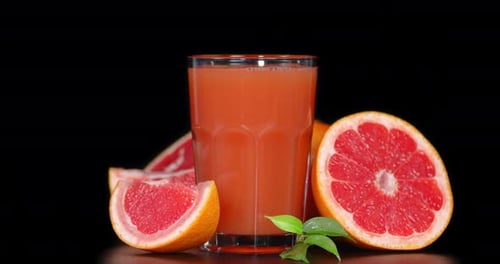 Un vaso de jugo de pomelo gira lentamente.