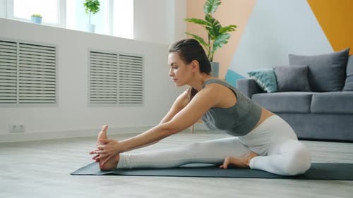 Woman Stretching on Yoga Mat Indoors