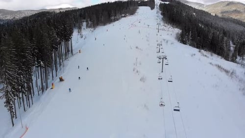 Luftaufnahme auf Skipisten mit Skifahrern und Skiliften im Skigebiet im Winter