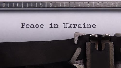Typing phrase "Peace in Ukraine" on retro typewriter.