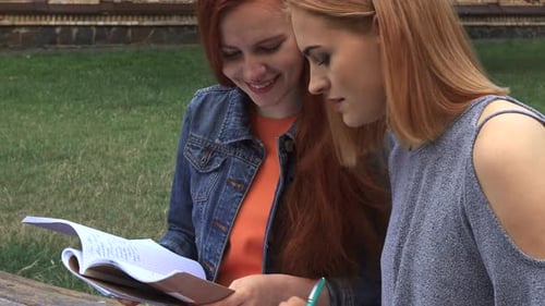 Blonde réécrivant le texte du cahier de notes de son amie