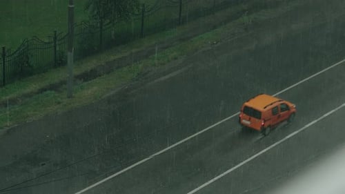 Autos bewegen sich mit starken Wasserströmen auf der Straße