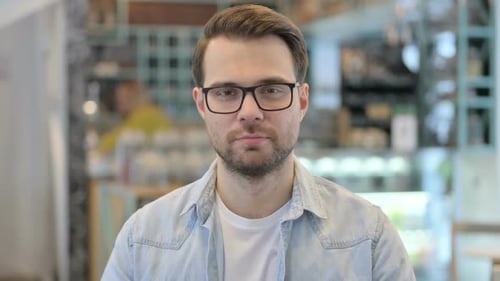 Junger Mann schaut in die Kamera