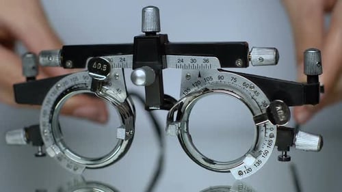 Hände legen optischen Versuchsrahmen auf den Tisch, Augenprüfgerät Nahaufnahme