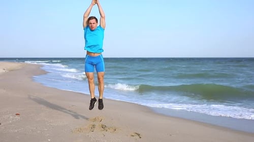 Jeune homme faisant de l'exercice de burpees à Ocean Beach à Slowmotion