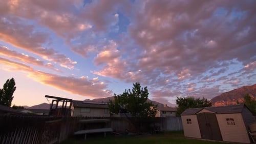 Colorful Clouds Drift Over Neighborhood at Sunset