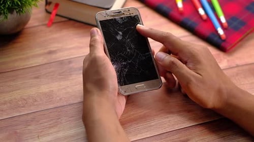 Close Up of Man Hand Holding Broken Smart Phone.
