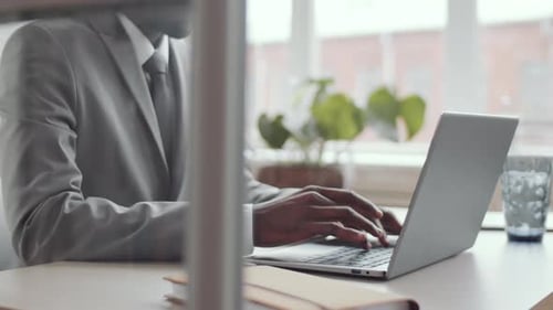 Midsection of Black Businessman Working on Laptop at Office Desk