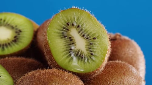 Kiwi Isolated on Blue Background Pouring Water on Fresh and Ripe Exotic Fruits