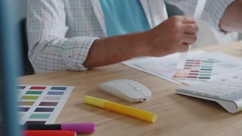 Closeup of Designer's Hands Working with Computer Developing Smartphone App at Desk