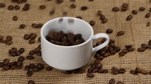 Roasted Coffee Beans Pouring Into a White Mug