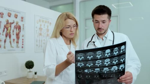 Doctors Reviewing Patient X-Ray in Clinical Setting