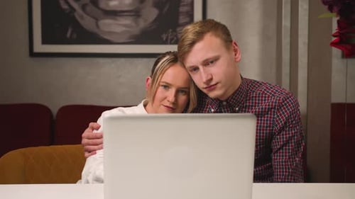 Close Up Young Couple Sitting at Home Use Laptop Watching Movie Shopping Online Together Browse