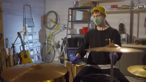 Man Wearing Mask and Gloves Playing Drums