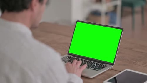 Young Man using Laptop with Green Screen