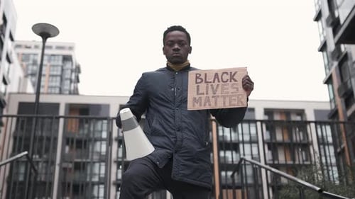 Person Holding Sign With Megaphone in Urban Setting