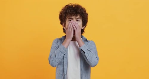 Allergy Concept. Studio Portrait of Little Boy Sneezing and Looking at Camera