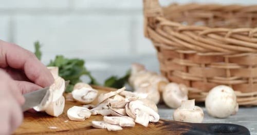 Person Slicing Mushrooms on a Cutting Board