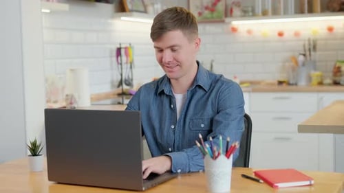 Man Working on Laptop in Bright Kitchen