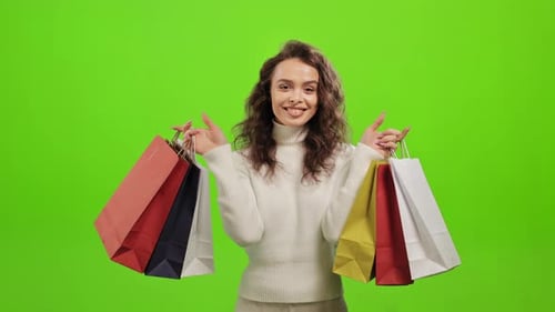 Smiling Woman Holding Up Shopping Bags