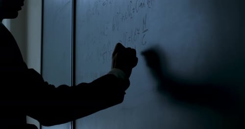 Wissenschaftler schreiben Formeln an Tafel