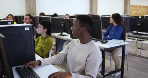 Young multiracial people using computers inside school classroom at university