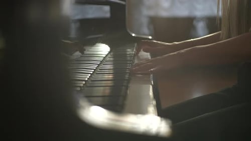 Woman Plays Piano Keys Gracefully Indoors