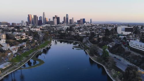 Tranquil Lake Reflects Majestic City Skyline at Sunset