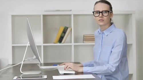 Woman Frustrated Using Computer at Desk in Office