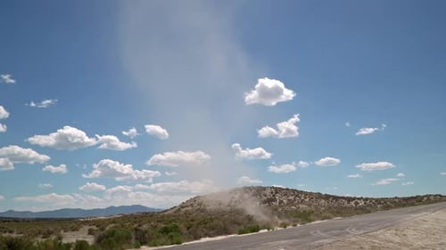 Dreckteufel wirbelt über eine Straße und sammelt Dreck in der Wüste von Utah