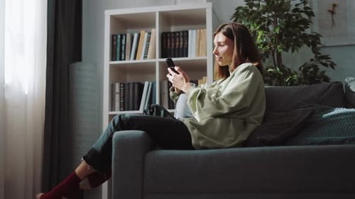 Woman Relaxing on Couch Using Phone