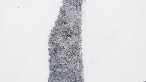 Woman is ice skating on frozen lake, top view