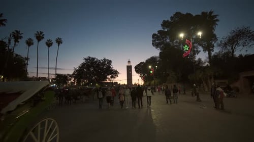Tourists And Citizens Walking Through Marrakesh At Dusk
