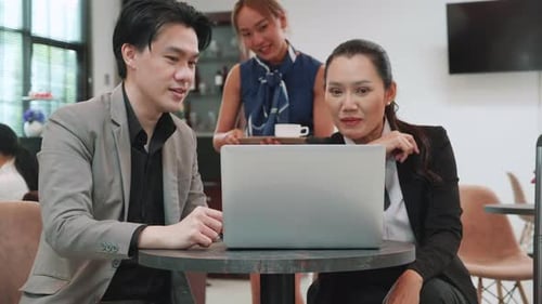 Colleagues Collaborating on Laptop in Bright Office