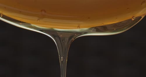 Honey Pouring On Spoon