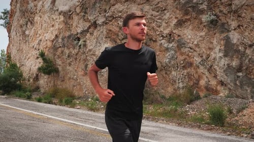 Young Man Jogging on Tropical Road