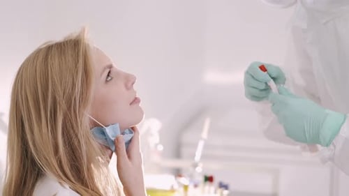 A Doctor in a Protective Suit Taking a Nasal Swab From a Person To Test for Possible Coronavirus