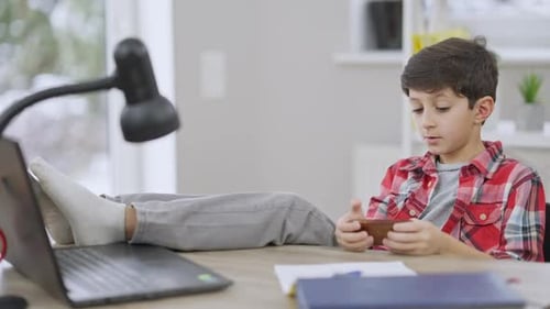 Young Boy Relaxing, Playing Games on Phone