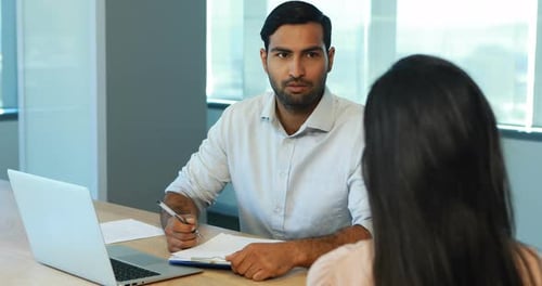 Man Interviewing Colleague in Modern Office Setting