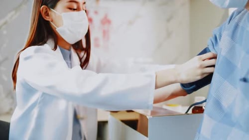 Doctor Checking Patient Blood Pressure in Hospital