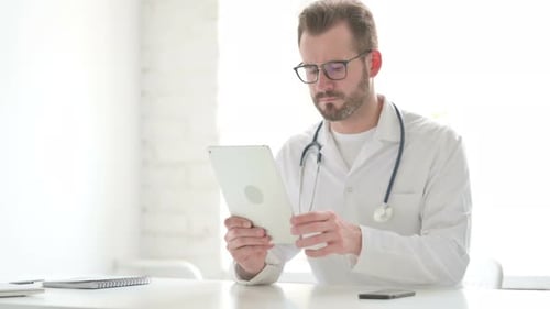 Doctor Using Tablet While Sitting in Office