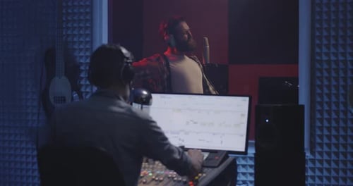 Sound Engineer and Singer Recording Vocals in Studio