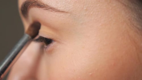Woman Applying Eyeshadow with Brush, Extreme Close Up