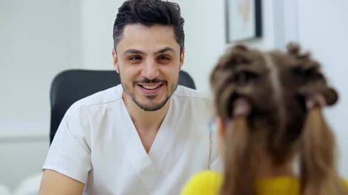 Doctor talking to child patient in clinic