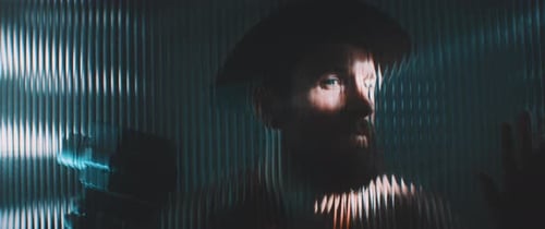 Man Behind Textured Glass in Dark Room