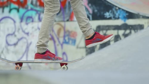 Skateboarder Rolling Through Urban Skate Park on Sunny Day