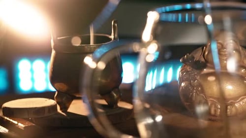Palitos de té vertidos sobre fondo de vidrio con aroma a humo retroiluminados por luz cálida